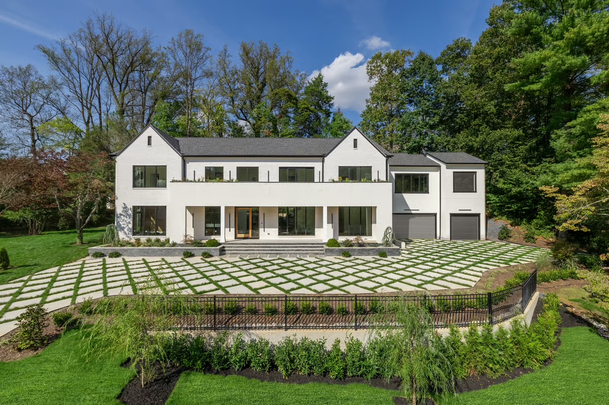 Wide exterior view of the completed Lybrook custom home with a grass-jointed block driveway and covered front porch